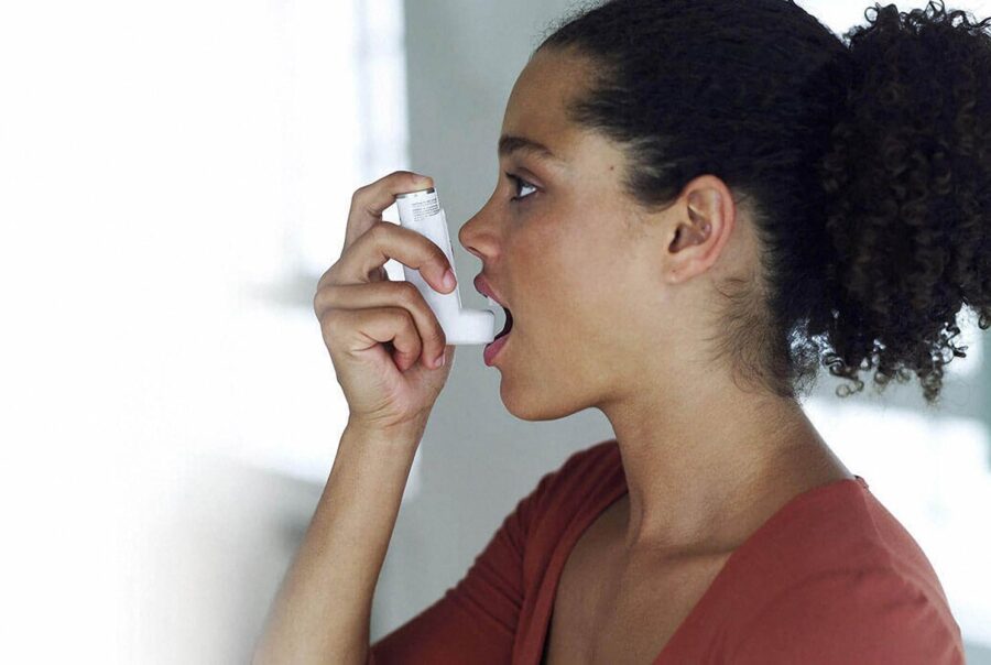 about asthma, young women using an asthma inhaler